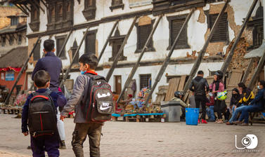 Students with masks walking alongside the earthquake affected school